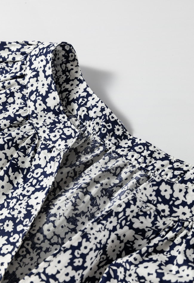 Blouse with navy and white floral print, featuring a notched neckline and gathered detail.