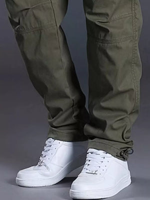 Men's green relaxed fit cargo pants with drawstring ankles and white sneakers