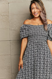 Black floral print midi dress with smocked bodice and off-the-shoulder neckline