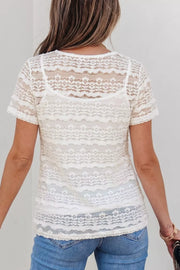 White sheer lace t-shirt with short sleeves and intricate patterned details, worn over a camisole.