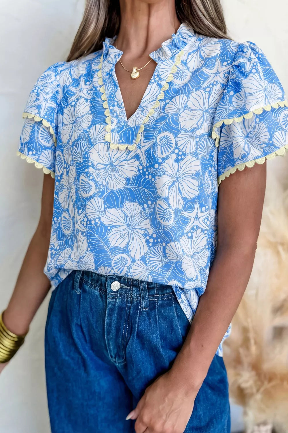 Tropical floral v-neck frill blouse with yellow trim and short sleeves.