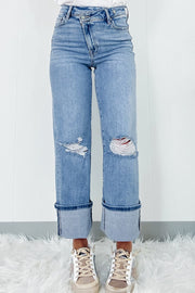 Medium wash wide-leg jeans with distressed knees and large cuffs.