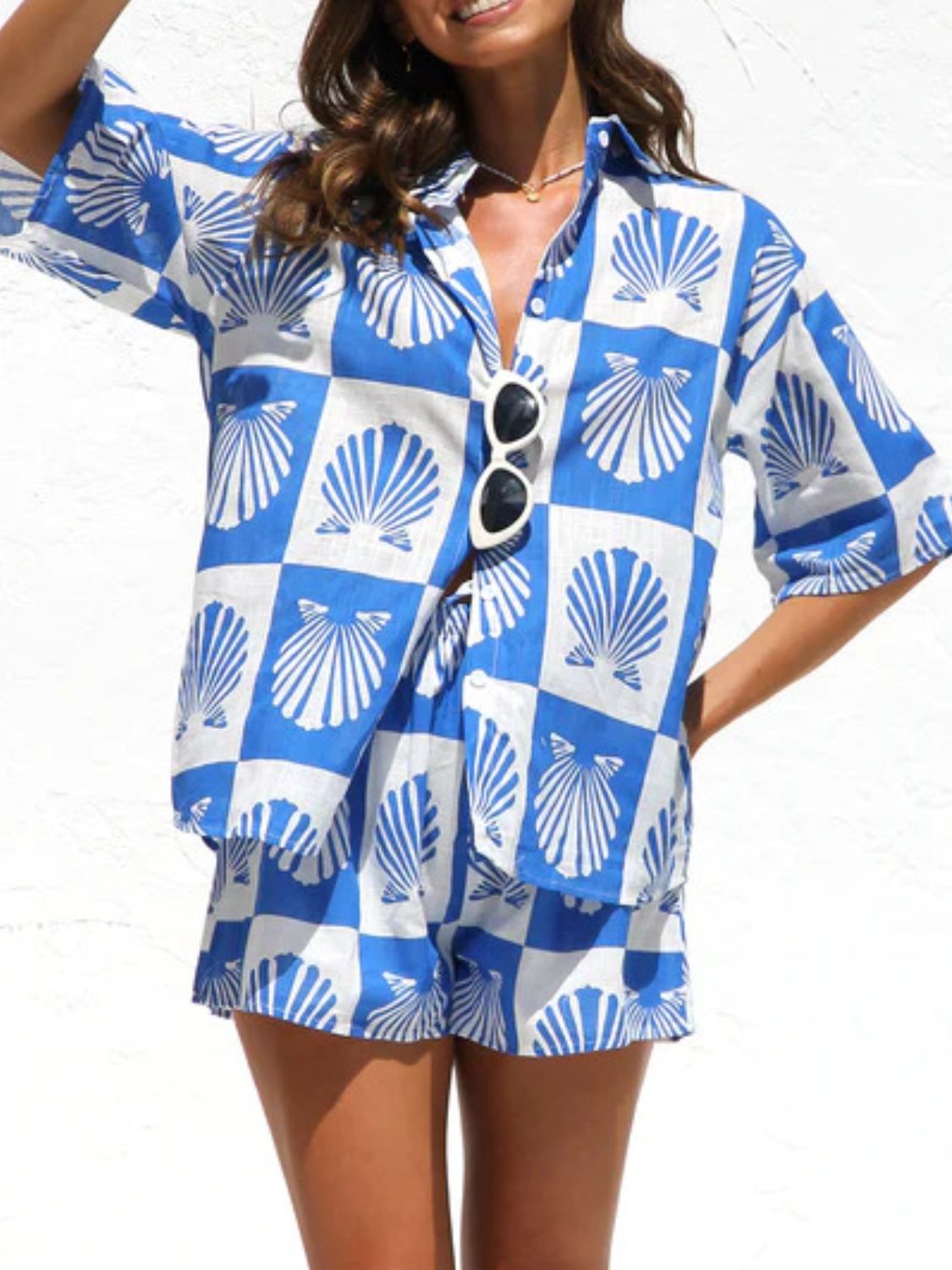 Blue and white checkered resort set with shell print, button-up shirt and shorts.