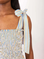 Smocked bodice set with rainbow stripe tie straps and ruffled neckline.