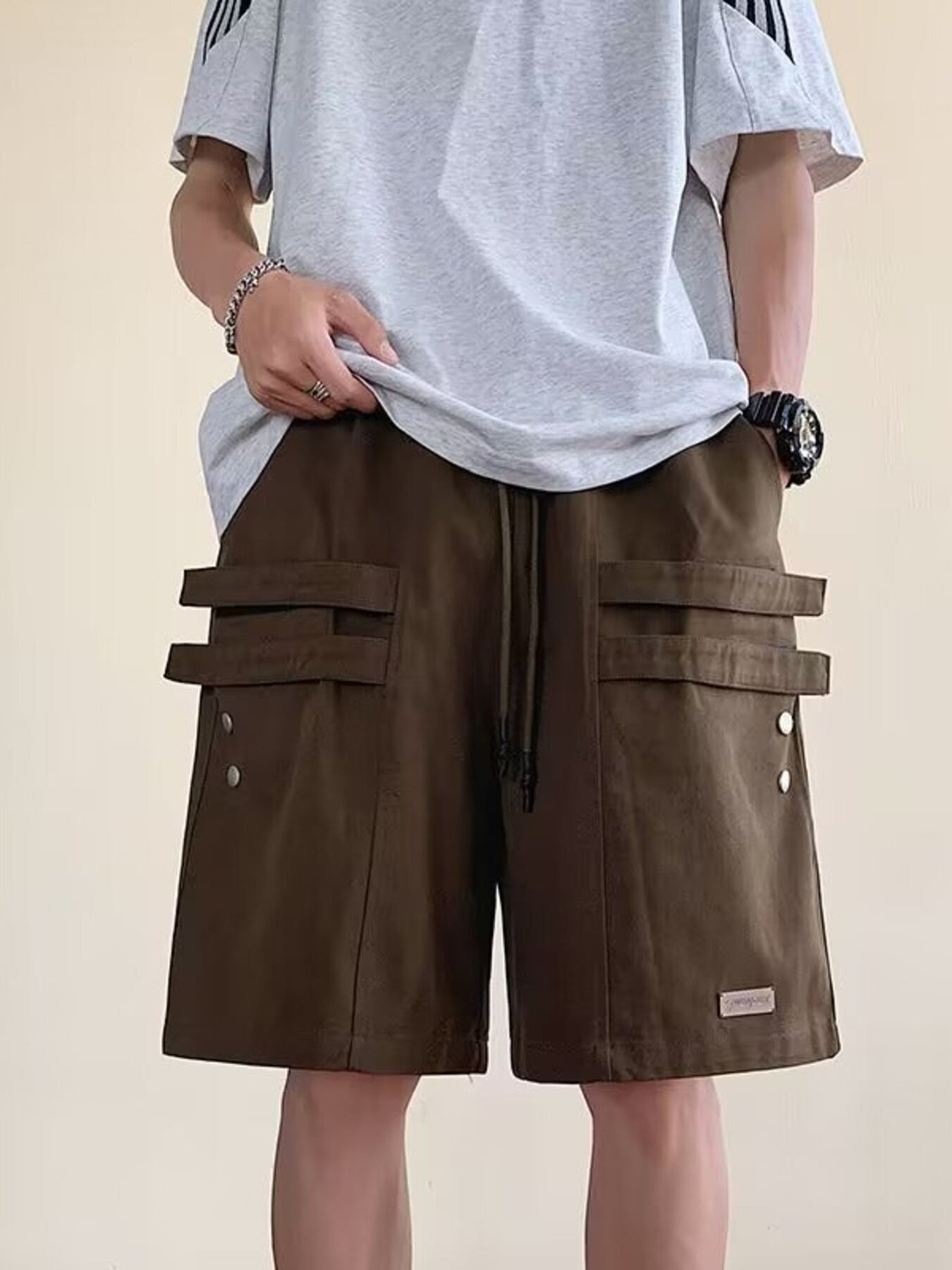 Men's brown cargo shorts with drawstring waist and multiple flap pockets.