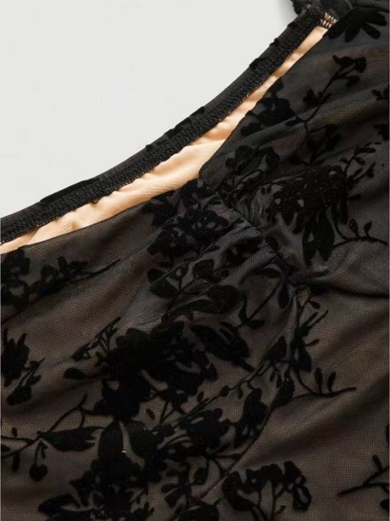 Black floral burnout mesh sweetheart mini dress with ruched detail.