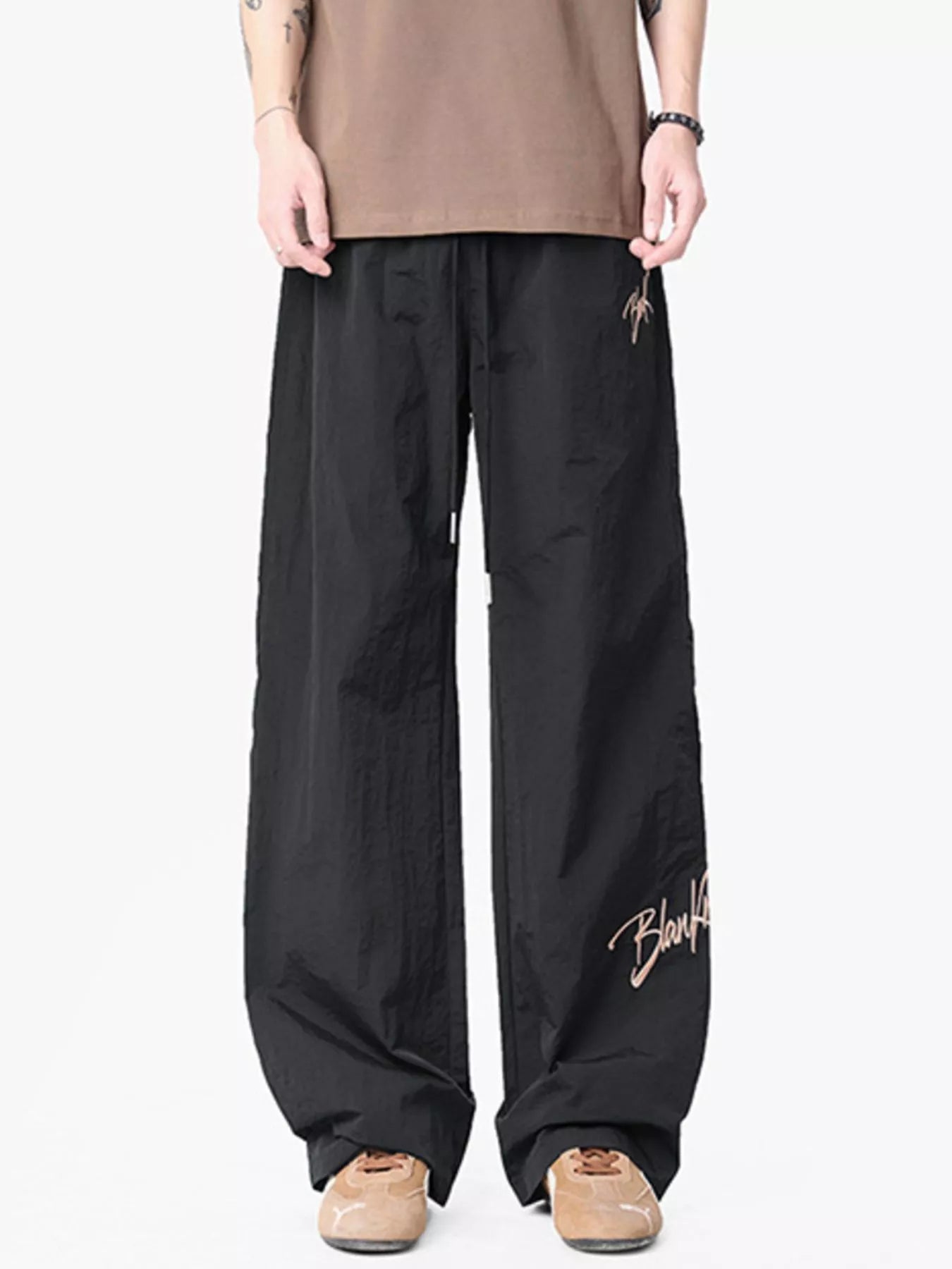 Black wide-leg drawstring pants with embroidered logo detail and a comfortable fit.