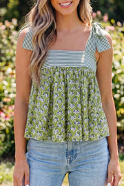 Floral tie-strap tank top with square neckline and blue print on green cotton.