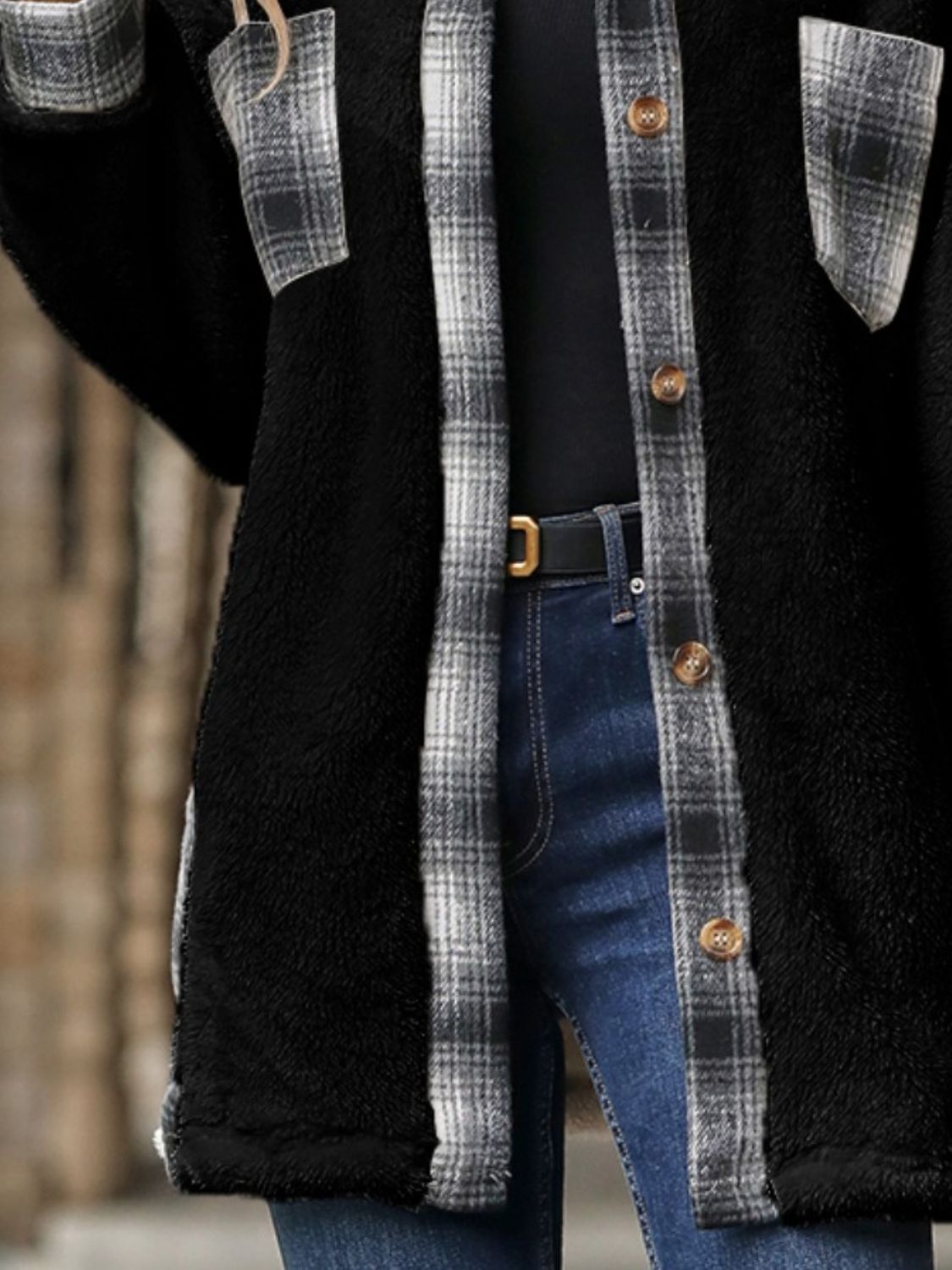 Black teddy shacket with plaid collar and pocket details, button front, worn over a black top and jeans.
