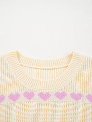 Cream knit sweater with a pink heart pattern and crew neck.