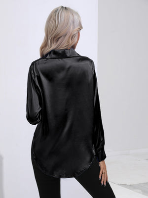 Black satin tie-front blouse with long sleeves and a curved hem.