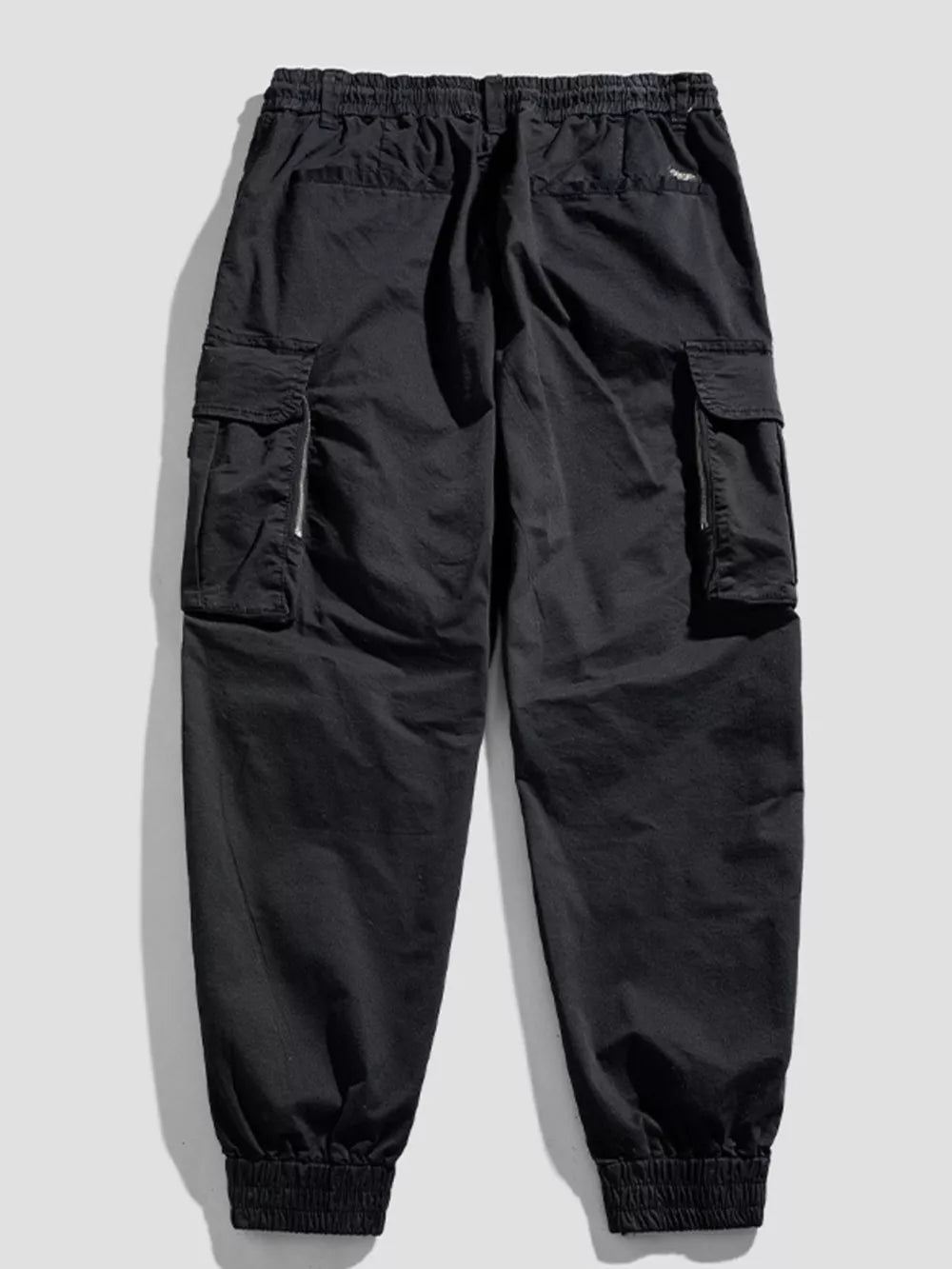 Black cargo joggers with flap pockets and zippered details.