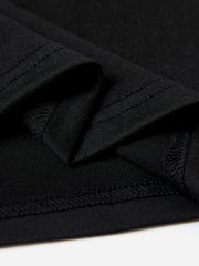 Black t-shirt detail showing textured fabric and double-stitched seams.