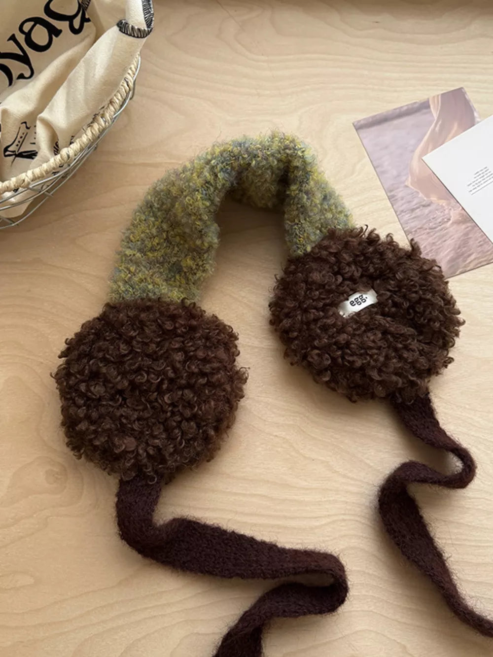 Plush sherpa earmuffs in brown with a textured green and yellow knit headband and ties.