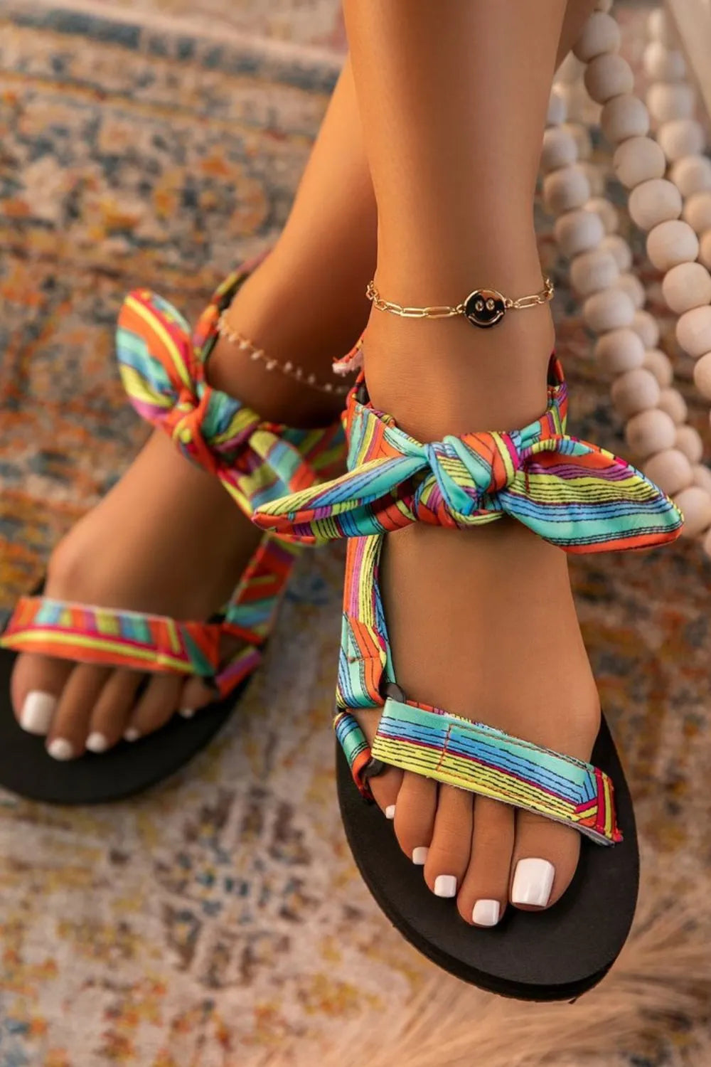 Bow-detail flat sandals in leopard, color, gray, or black.