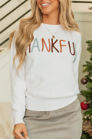 White crewneck sweater with colorful embroidered "THANKFUL" text, long sleeves, ribbed cuffs and hem.