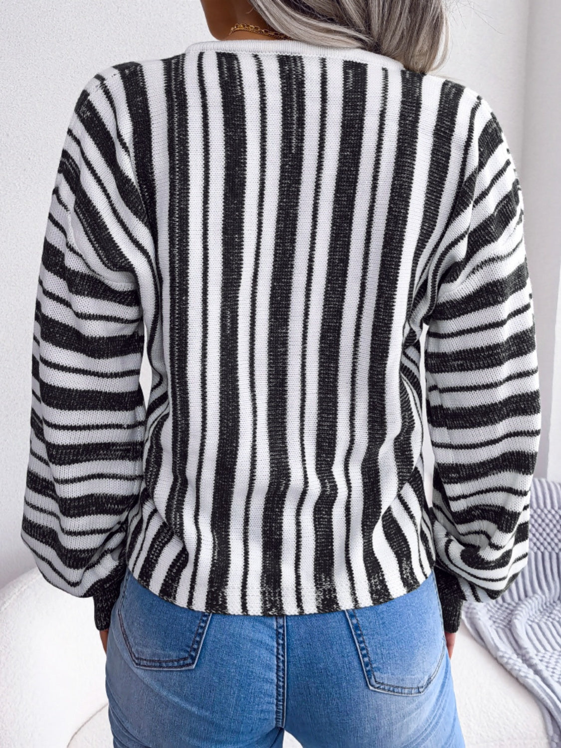 Black and white striped knit cropped pullover sweater with long sleeves.