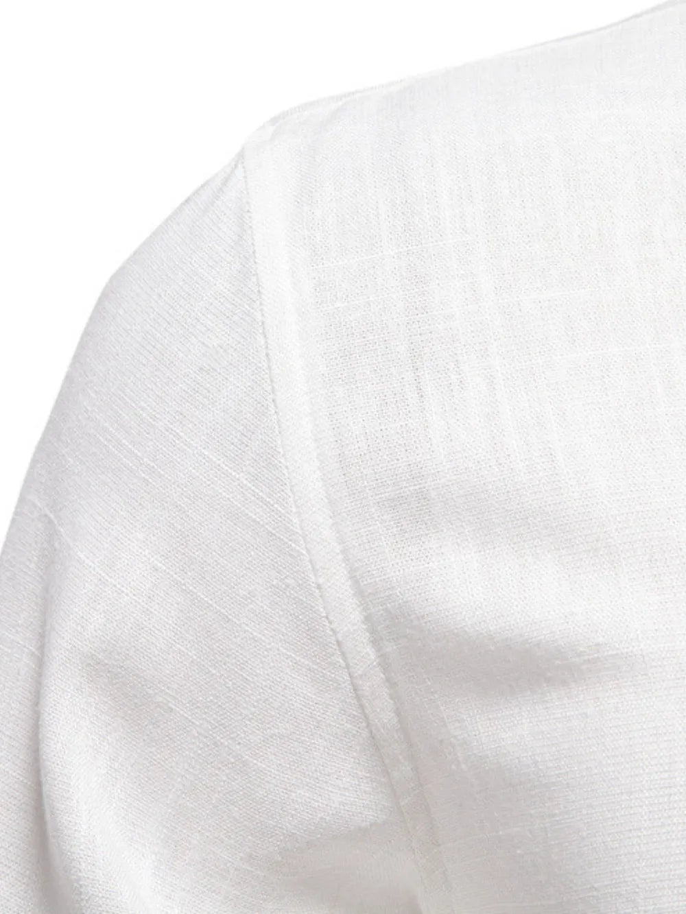 White linen shirt detail showing shoulder seam and textured fabric.