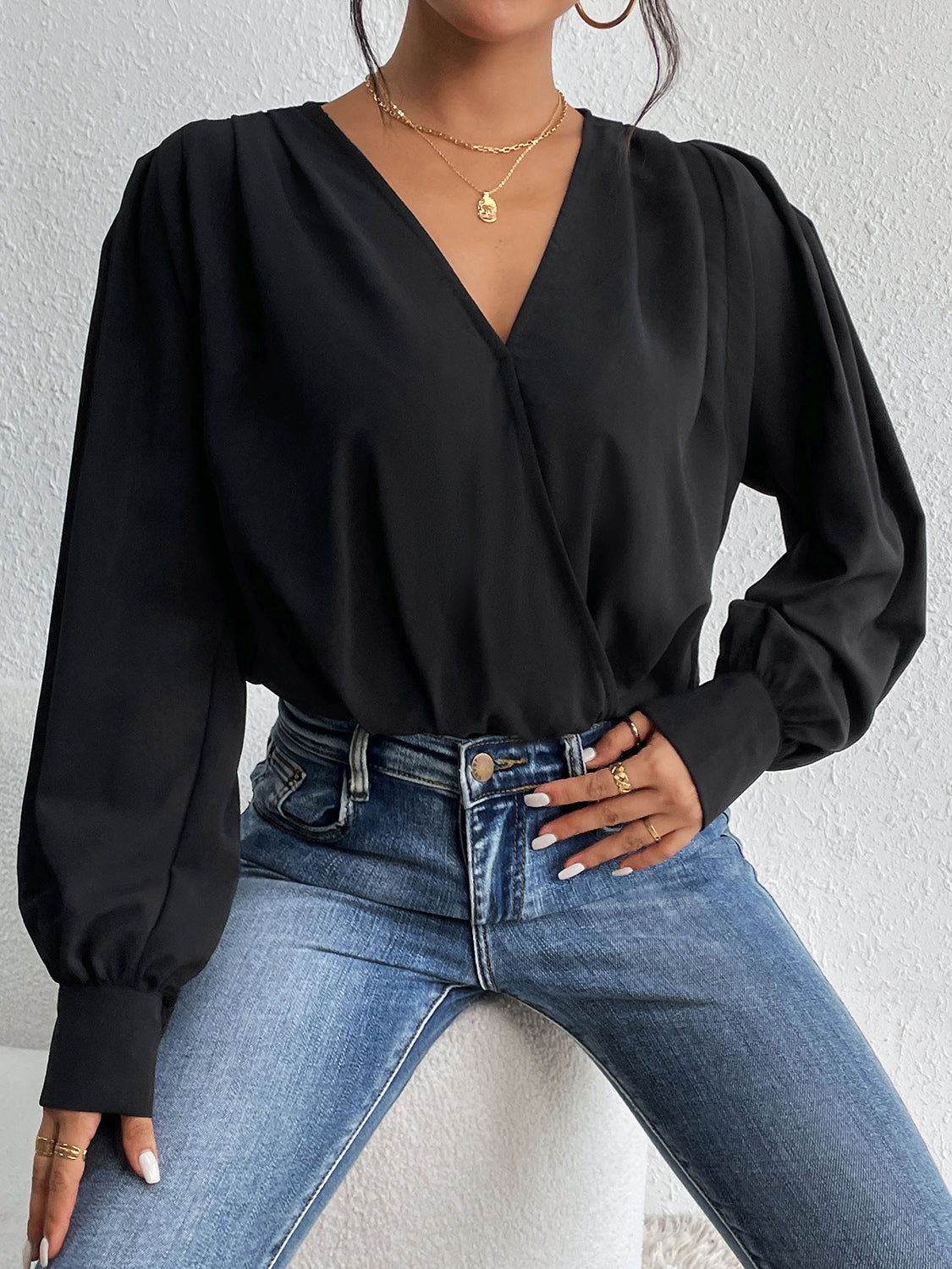 Black surplice bodysuit with balloon sleeves and a V-neckline.