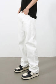 Relaxed ivory denim jeans with a straight leg, styled with a black t-shirt and two-tone sneakers.