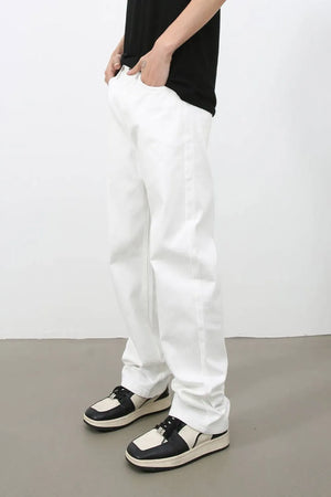 Relaxed ivory denim jeans with a straight leg, styled with a black t-shirt and two-tone sneakers.