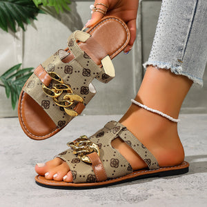 Patterned slide sandals in apricot with gold chain accent and brown straps.