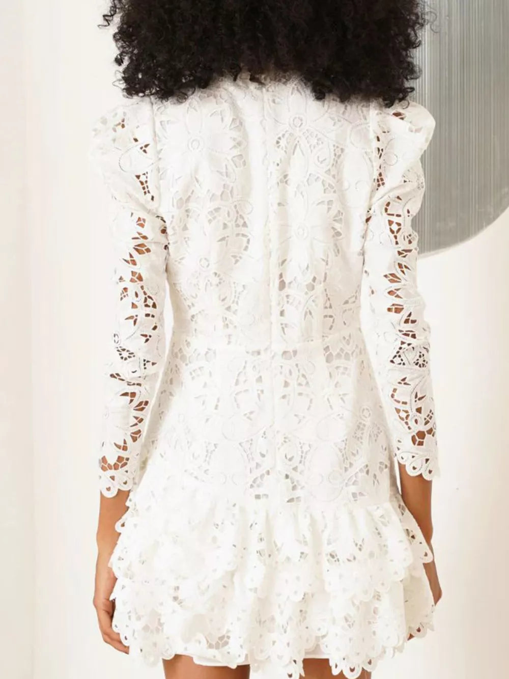 White floral lace mini dress with mock neck, puff sleeves, and tiered ruffle hem.