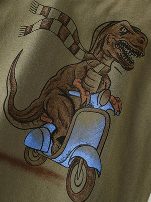 Toddler t-shirt with a brown dinosaur graphic wearing a checkered scarf and riding a blue scooter.