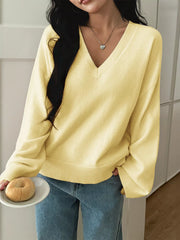 Pastel yellow V-neck knit sweater with ribbed cuffs and hem.