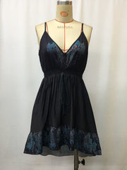 Black floral mini cami dress with V-neck, smocked waist, and ruffled hem.