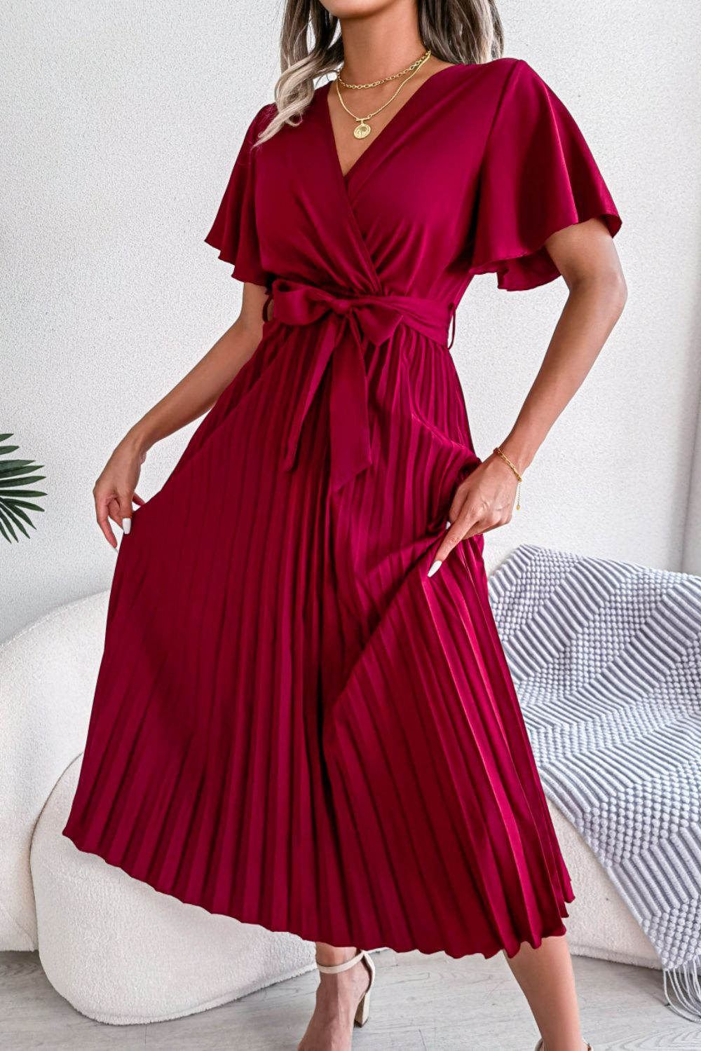 Red wrap bodice pleated midi dress with flutter sleeves and belted waist