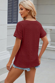 Burgundy perforated tee with rolled short sleeves and a V-neck, styled with denim shorts.
