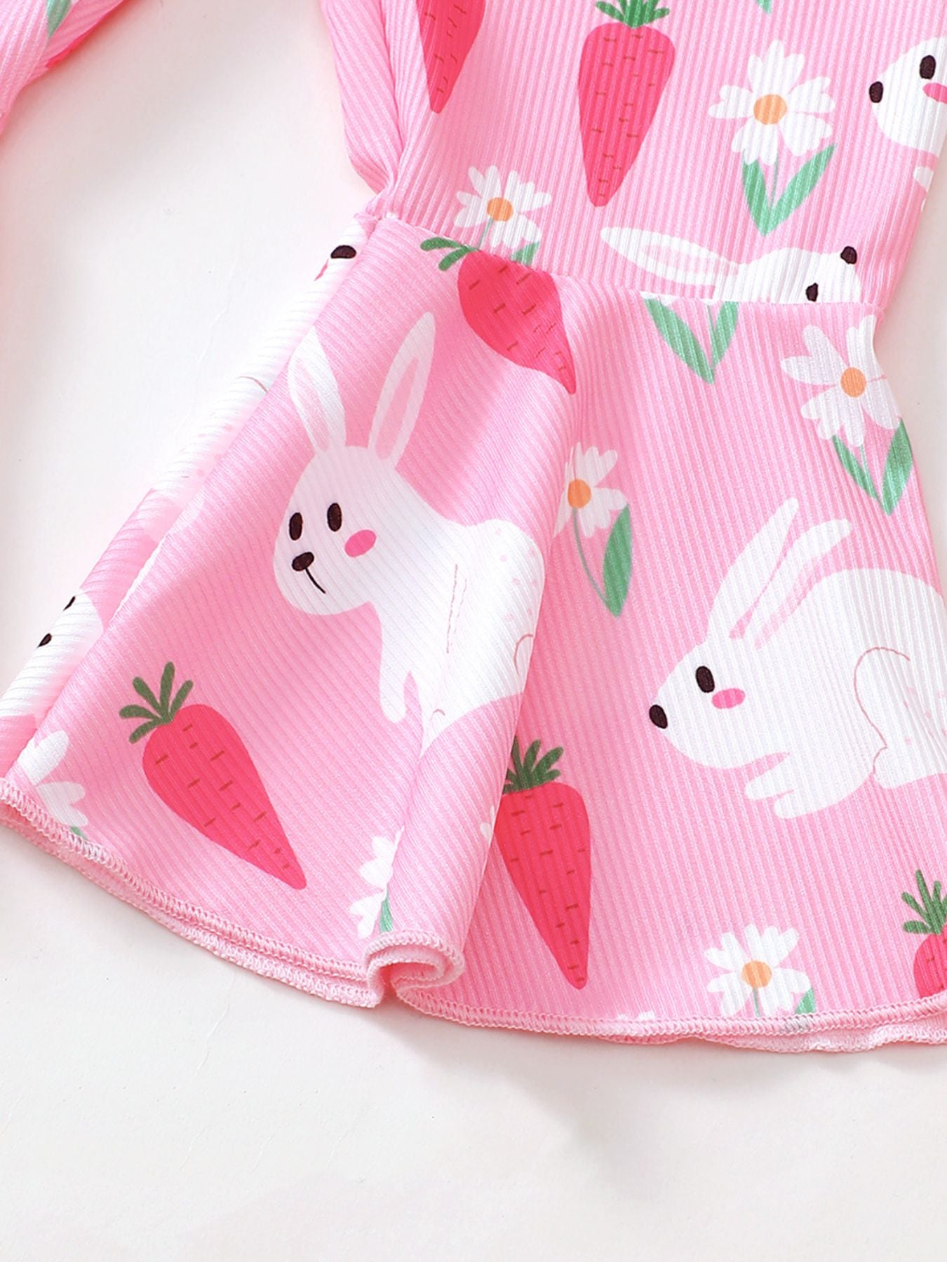 Pink ribbed flare overalls with a playful bunny and carrot print.
