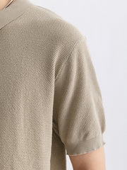 Textured knit zip-up polo shirt in apricot with short sleeves and ribbed cuffs.