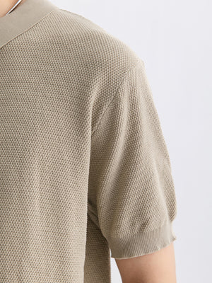 Textured knit zip-up polo shirt in apricot with short sleeves and ribbed cuffs.