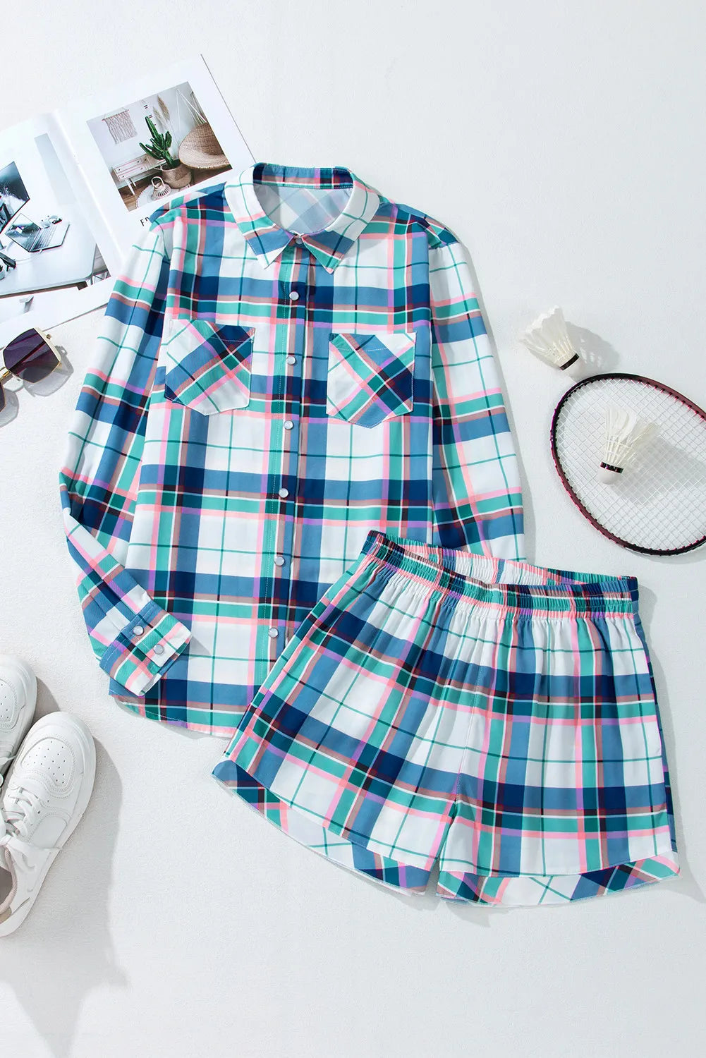 Plaid pajama set with long sleeve button-up shirt and shorts, featuring ruffled hem detail.