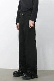 Black denim balloon trousers with a relaxed fit and visible stitching detail.