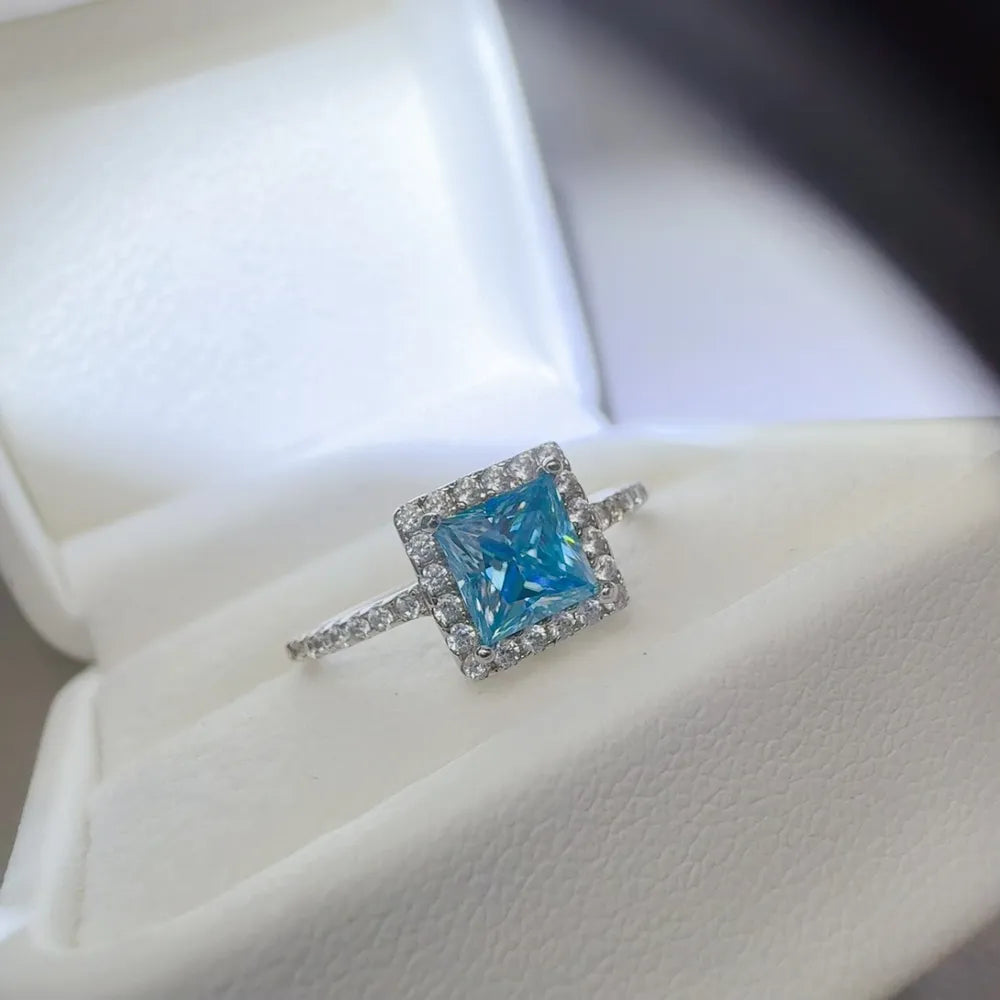 Silver ring with ice blue square halo diamond accent.