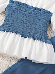 Blue smocked blouse with white ruffled peplum, paired with denim pants.