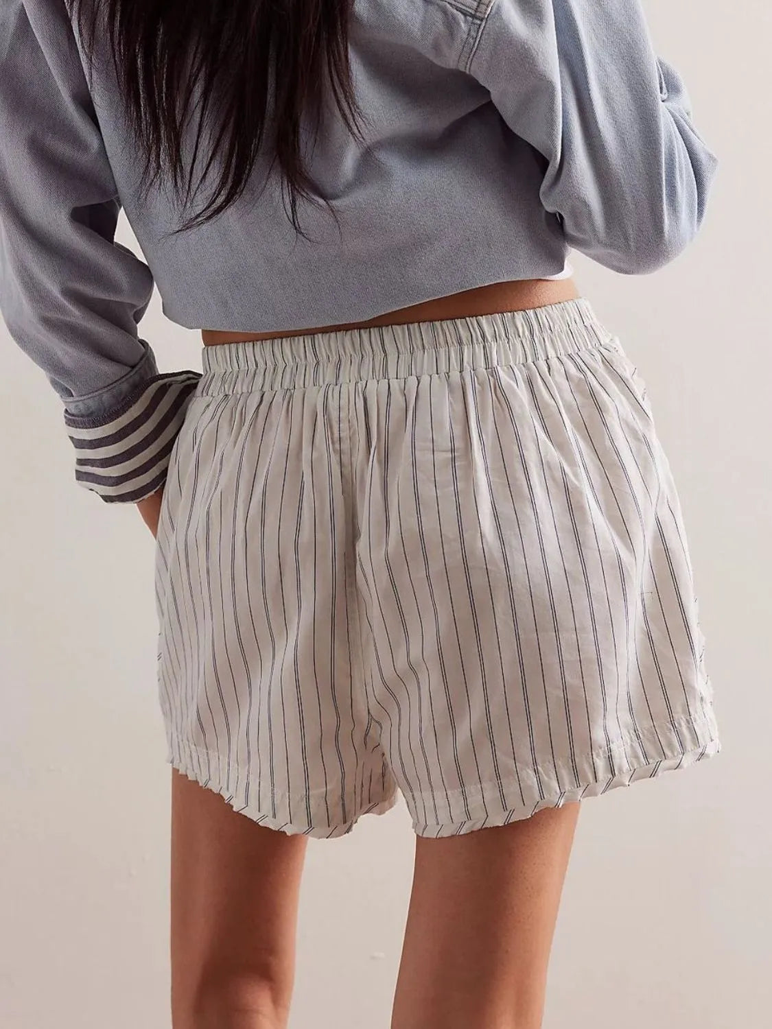 White boxer shorts with navy pinstripes and an elastic waistband.