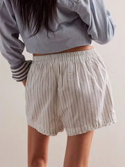 White boxer shorts with navy pinstripes and an elastic waistband.