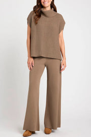Sleeveless ribbed turtleneck sweater in taupe acrylic, styled with matching wide-leg pants.