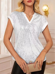 White sequin cap sleeve blouse with V-neck, styled with a clutch.