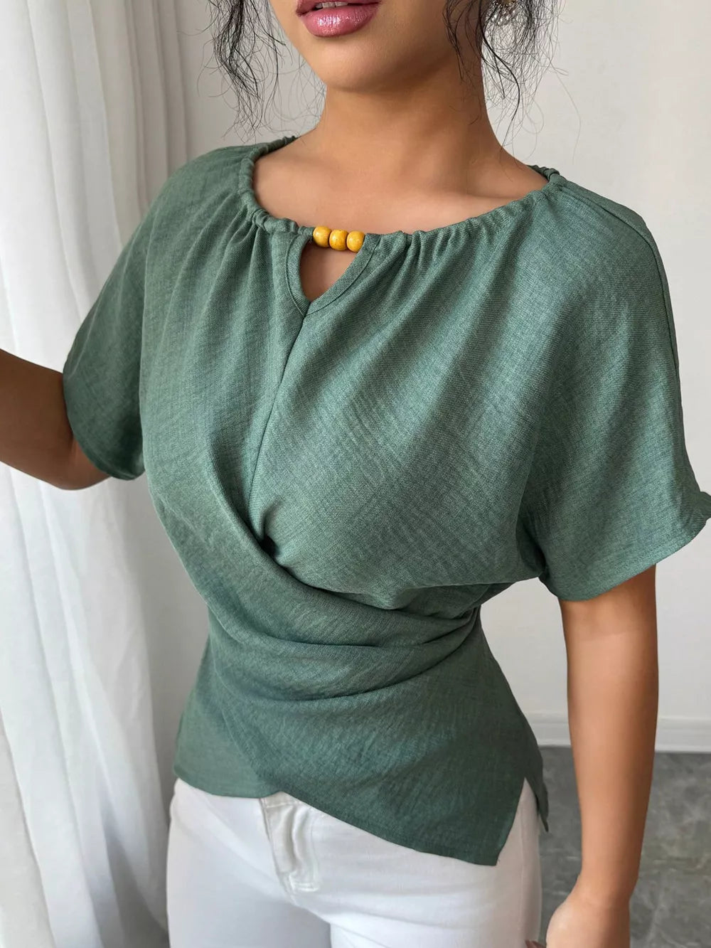 Green short sleeve maternity blouse with beaded keyhole neckline and draped front