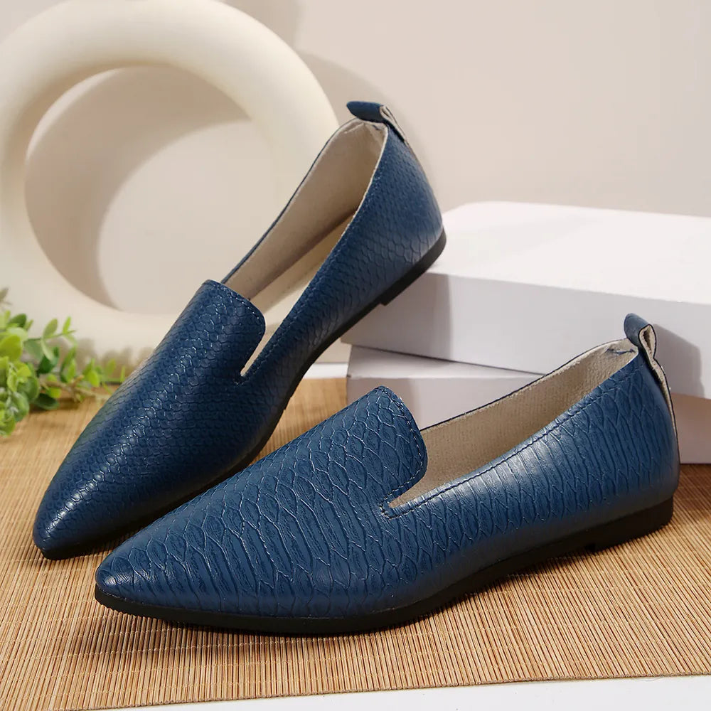 Navy textured pointed-toe slip-on loafers with a subtle snake print detail.