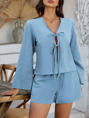 Light blue linen tie-front top with bell sleeves and matching shorts.