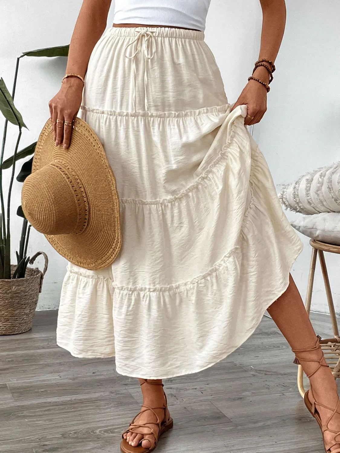 Cream tiered midi skirt with drawstring waist and textured fabric.