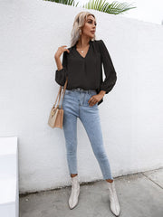 Black Swiss dot sleeve gathered blouse with V-neck and ruffled trim.