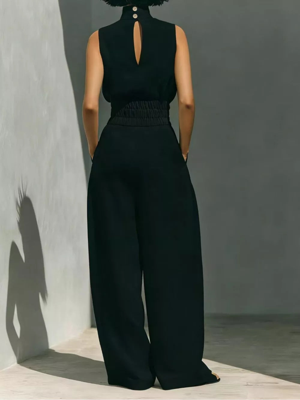 Black sleeveless turtleneck set with smocked waist and wide-leg pants