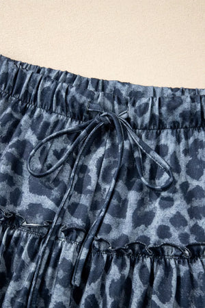 Maternity pants in dark navy with leopard print, elastic waist, drawstring, and ruffled hem.